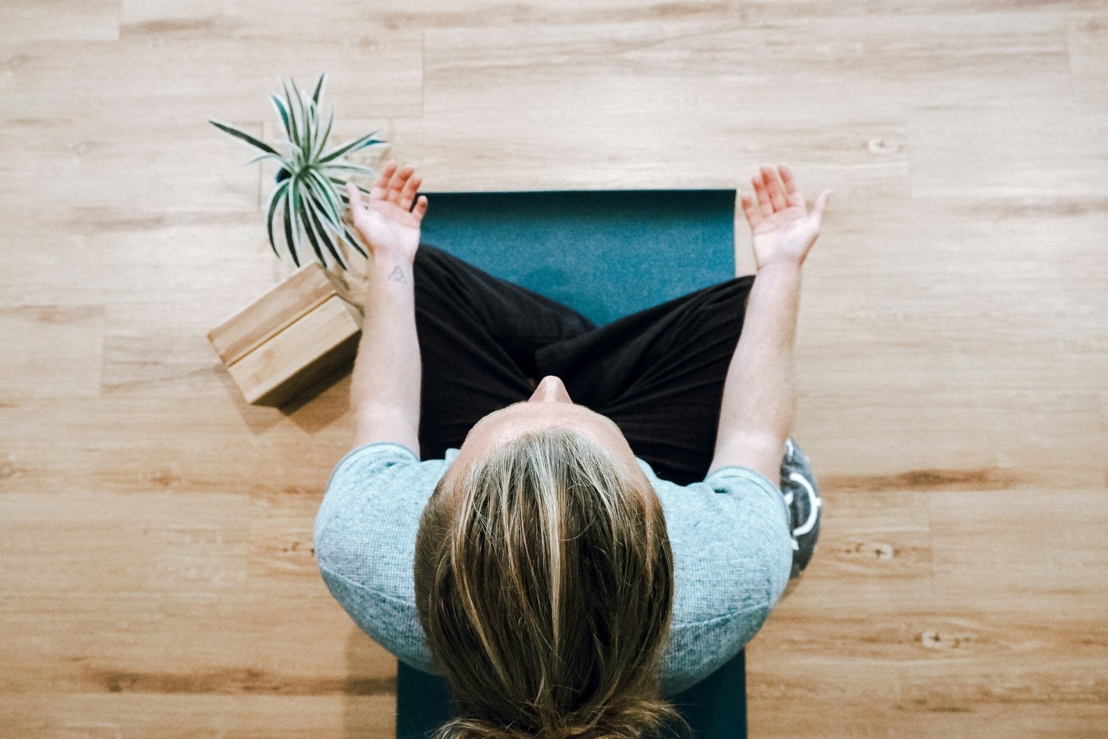 a person sitting on a mat with their hands in the air meditation  