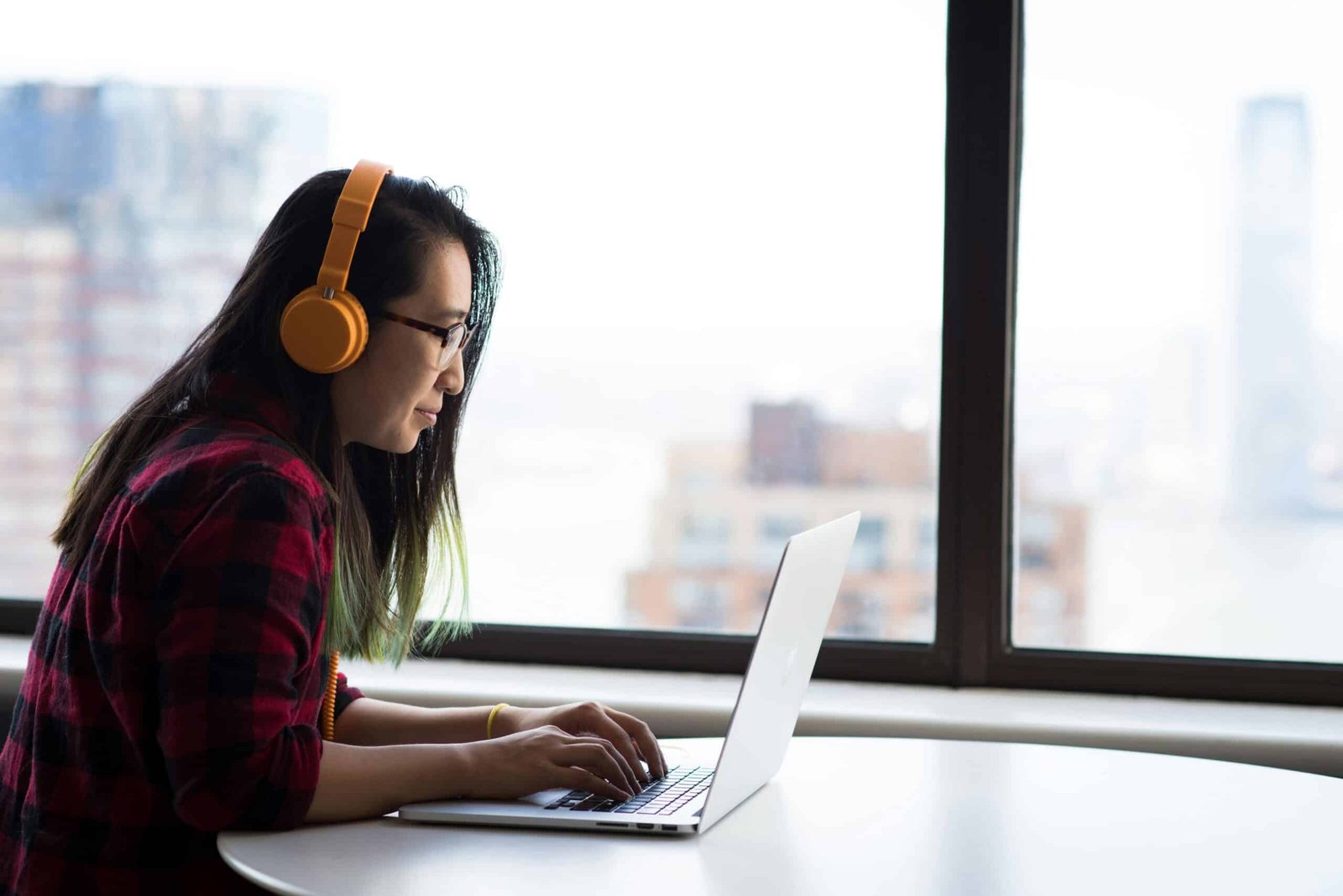 a woman wearing headphones and using a laptop