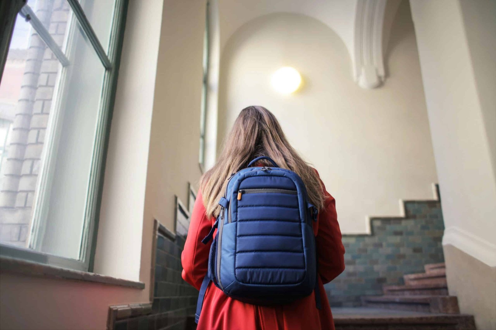 girl walking upstair with her backpack to learn a new language 