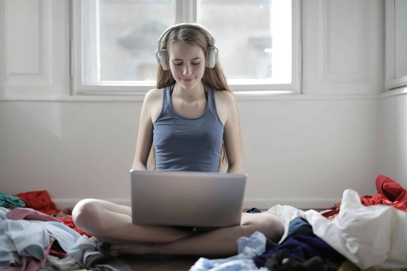 a woman sitting on the floor with headphones on
